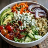 Healthy Simple Grain Bowl with grilled chicken, quinoa, cucumbers, carrots, and pumpkin seeds, ready for lunch.