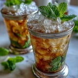 A refreshing non-alcoholic mint julep mocktail, served in a classic silver cup with a generous mint garnish and crushed ice.