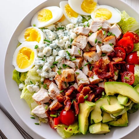 Perfectly layered Cobb salad, featuring juicy chicken, crispy bacon, and creamy avocado, ready to serve.