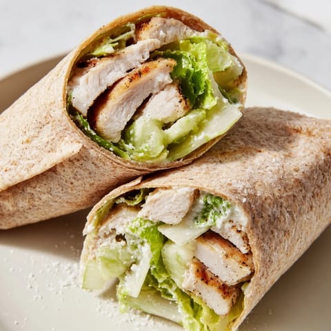 A tempting close-up of a Chicken Caesar Wrap, showing fresh lettuce and creamy dressing.