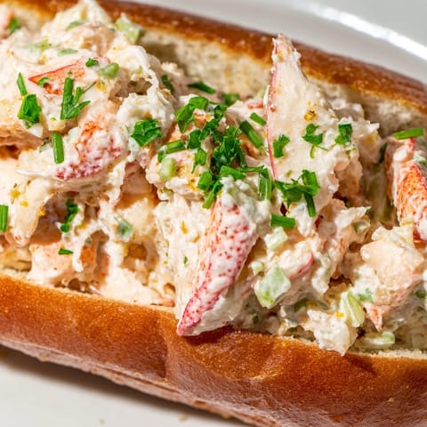 Golden, buttery New England lobster roll overflowing with tender lobster meat, ready to enjoy.