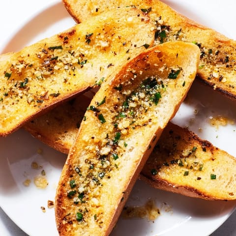 Warm Garlic Bread, brushed with herb butter, presents a savory aroma, perfect appetizer for dinner tonight.