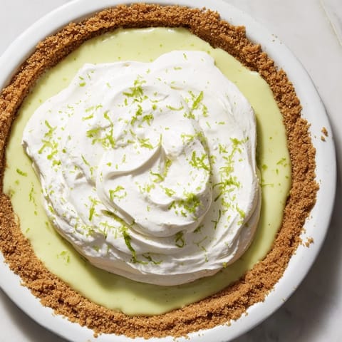 This Key Lime Pie shows a perfect golden crust and bright green lime filling awaiting a bite.
