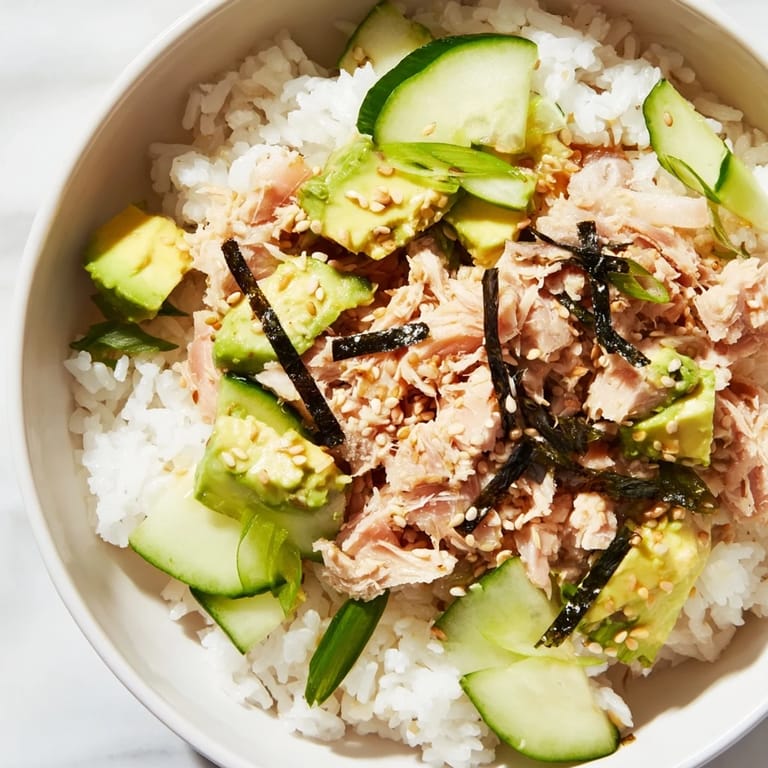 Colorful Tuna Avocado Rice Bowl garnished with scallions and nori, perfect for a quick, healthy lunch.  