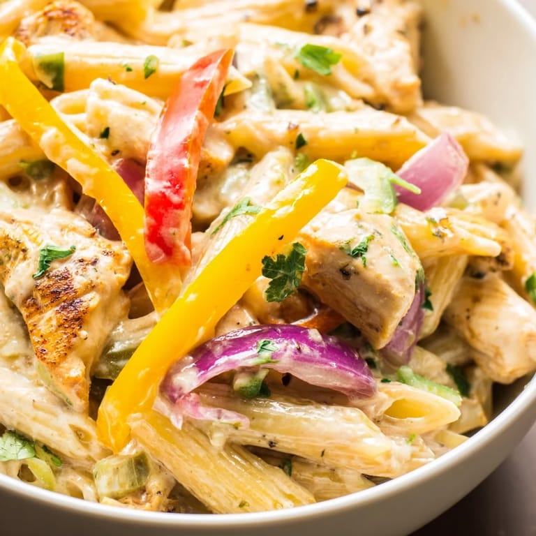 Golden, fajita-spiced chicken strips and pasta twirls in a cheesy, creamy sauce dotted with vibrant red, yellow, and green bell peppers.  