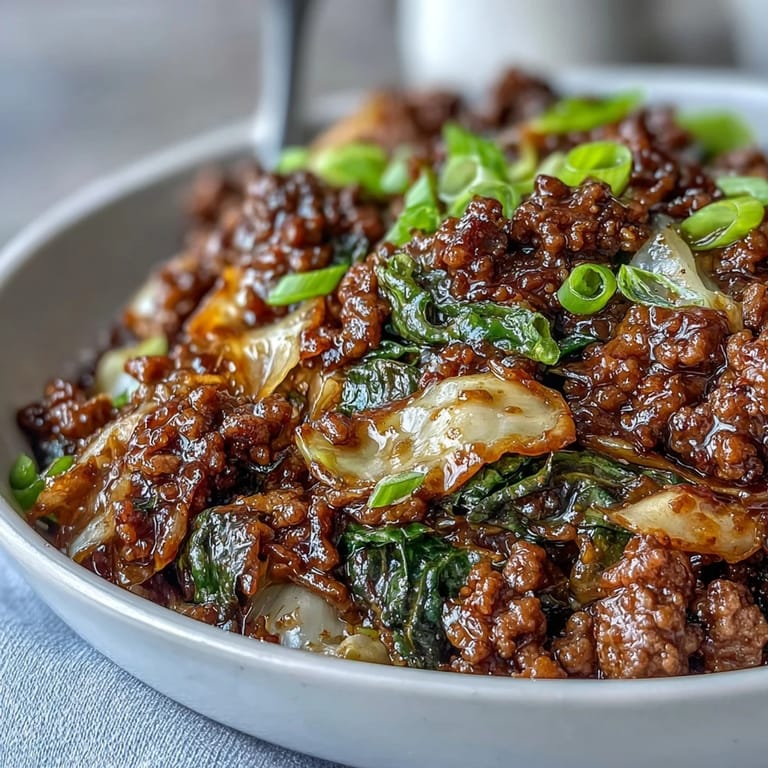 Tossing fresh cabbage and browned ground beef for this Chinese Ground Beef and Cabbage Stir-Fry in a hot wok.