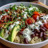 Three-Bean Power Bowl topped with sliced avocado, cherry tomatoes, and fresh cilantro, served in a rustic ceramic bowl for a nourishing lunch.