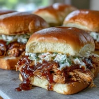 Juicy pulled BBQ chicken piled high on soft brioche buns, topped with creamy coleslaw and tangy barbecue sauce.